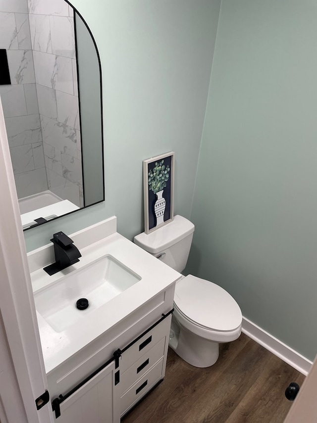 bathroom with vanity, wood finished floors, toilet, and baseboards