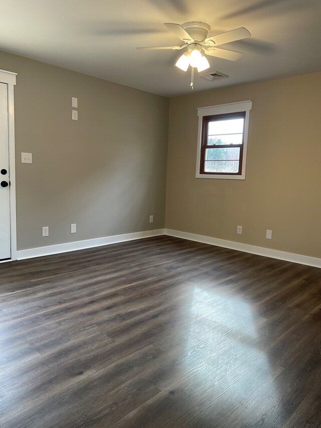 spare room featuring dark wood-type flooring and ceiling fan