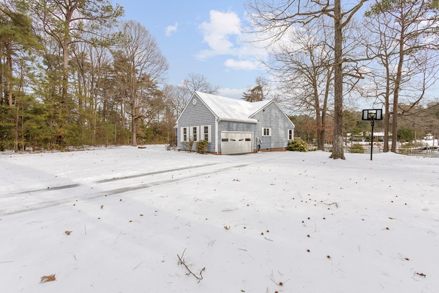 view of snowy exterior featuring a garage