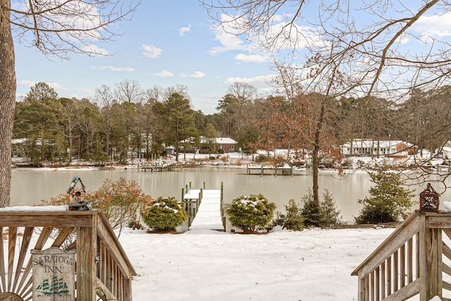 snow covered deck with a boat dock and a water view