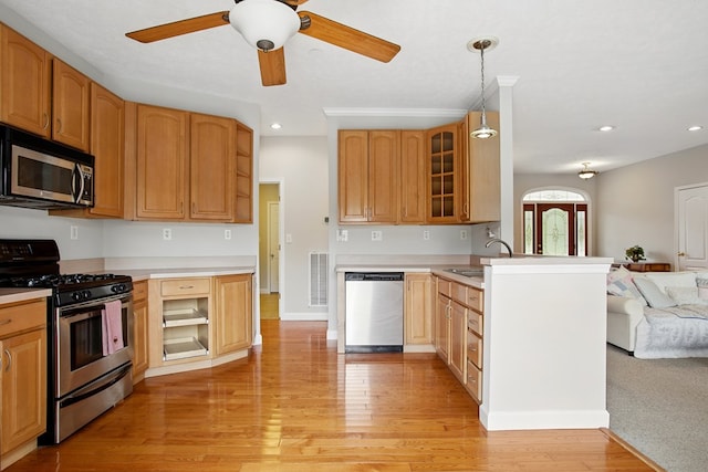 kitchen with visible vents, open floor plan, appliances with stainless steel finishes, glass insert cabinets, and ceiling fan