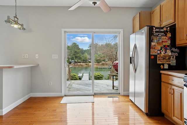 kitchen featuring pendant lighting, stainless steel refrigerator with ice dispenser, light wood-style floors, baseboards, and ceiling fan
