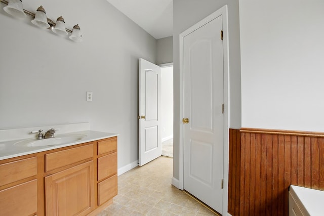 bathroom with vanity, wooden walls, and wainscoting