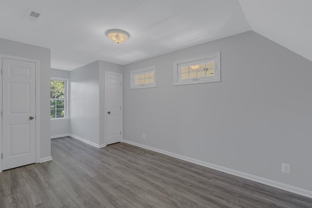 bonus room with hardwood / wood-style floors and vaulted ceiling