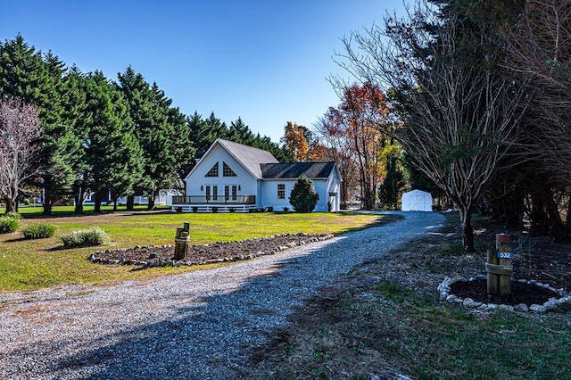 view of front of home featuring a storage shed and a front lawn