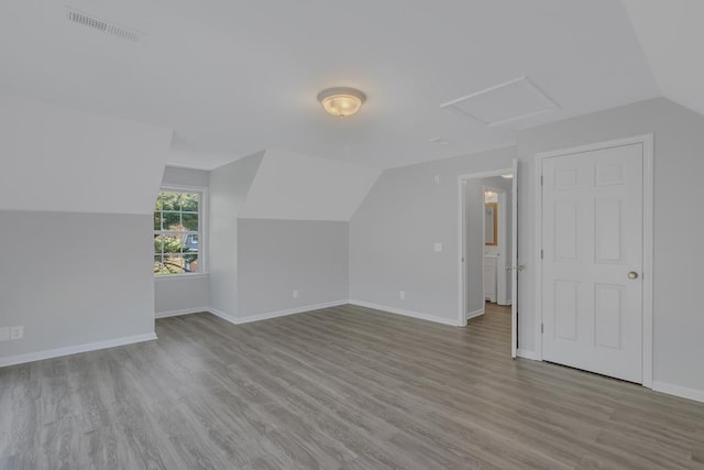 additional living space featuring lofted ceiling and light wood-type flooring