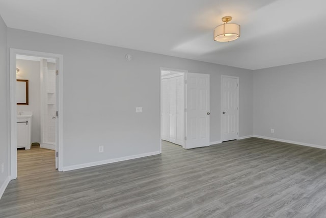 interior space with ensuite bath, light hardwood / wood-style floors, and two closets