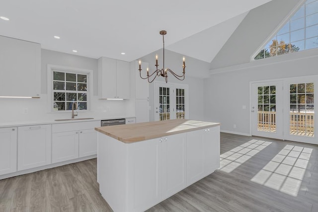 kitchen with white cabinetry, sink, a center island, and pendant lighting