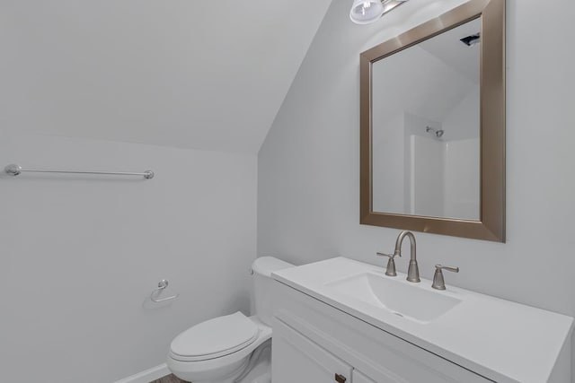 bathroom featuring vanity, toilet, walk in shower, and lofted ceiling