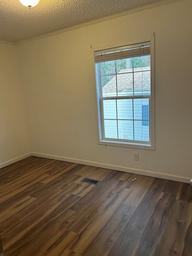 unfurnished room with crown molding, dark wood-type flooring, and a textured ceiling