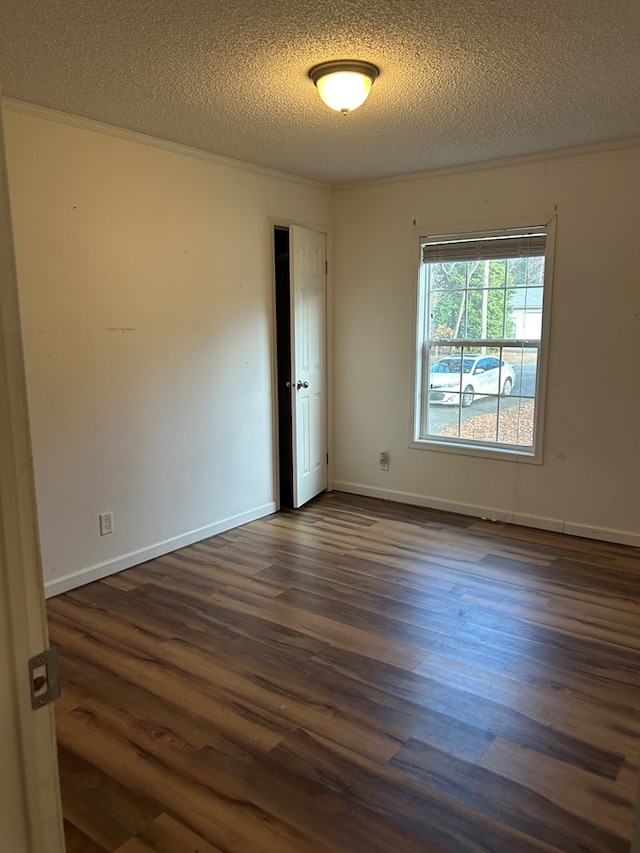 unfurnished room with crown molding, dark hardwood / wood-style flooring, and a textured ceiling