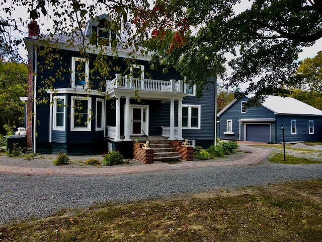 view of front of home with covered porch, a garage, and a balcony