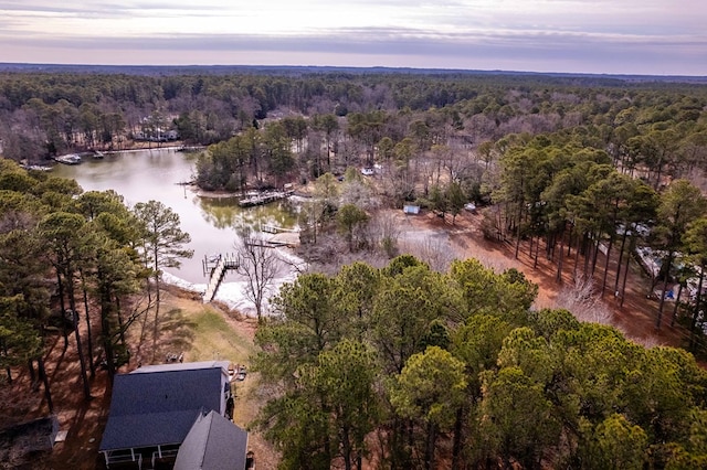 aerial view at dusk with a water view and a forest view