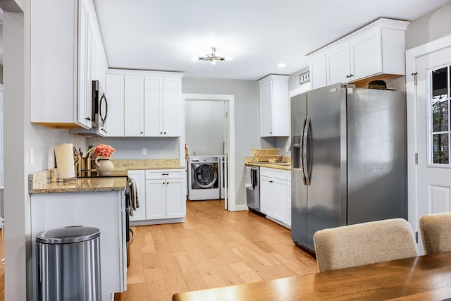 kitchen featuring washer / dryer, light wood-style flooring, light stone counters, stainless steel appliances, and white cabinetry