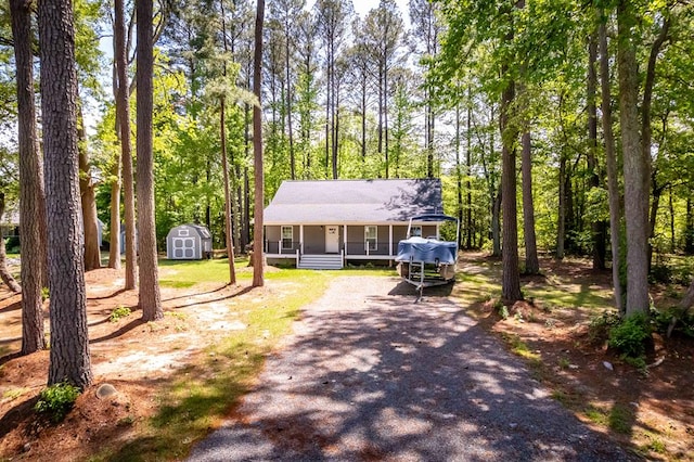 146 Portal Dr, Montross, VA 22520 - view of front of property with a porch, a storage shed, an outbuilding, and dirt driveway
