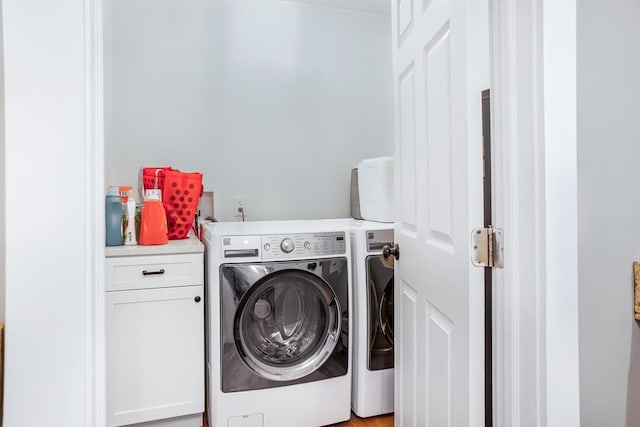 clothes washing area with cabinet space and washer and clothes dryer