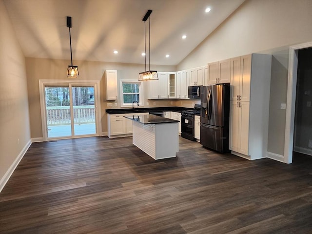 kitchen with white cabinets, a center island, hanging light fixtures, and appliances with stainless steel finishes