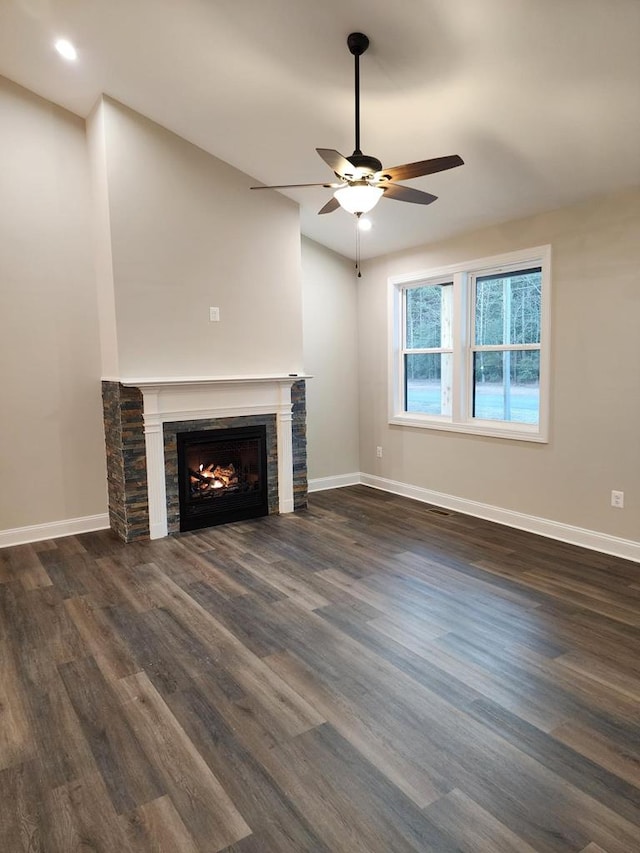 unfurnished living room featuring dark hardwood / wood-style floors, ceiling fan, and a fireplace