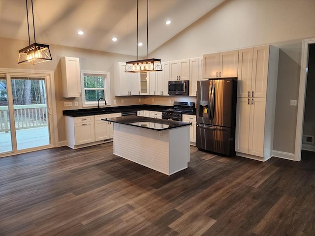 kitchen with a center island, white cabinets, pendant lighting, and appliances with stainless steel finishes