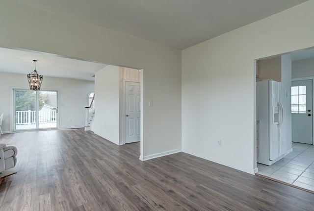 284 Palmer Dr, Lottsburg, VA 22511 - spare room featuring a notable chandelier, a healthy amount of sunlight, stairs, and wood finished floors