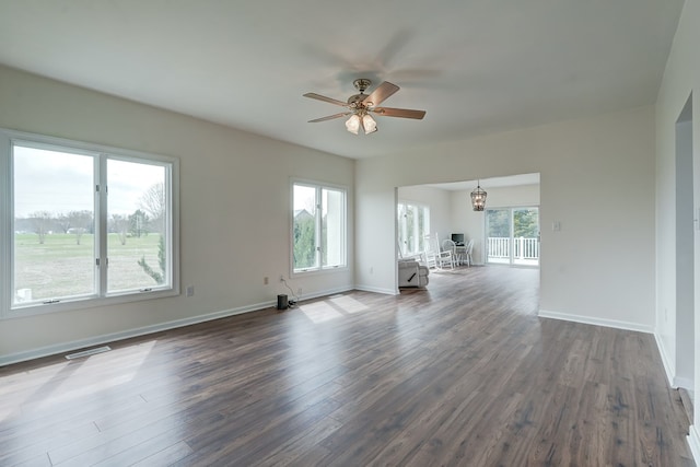 284 Palmer Dr, Lottsburg, VA 22511 - unfurnished living room with ceiling fan with notable chandelier, a wealth of natural light, baseboards, and dark wood-type flooring