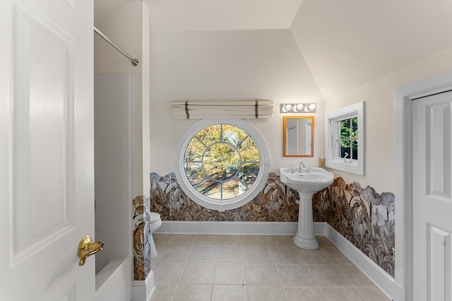 bathroom featuring bathtub / shower combination, tile patterned floors, toilet, and lofted ceiling