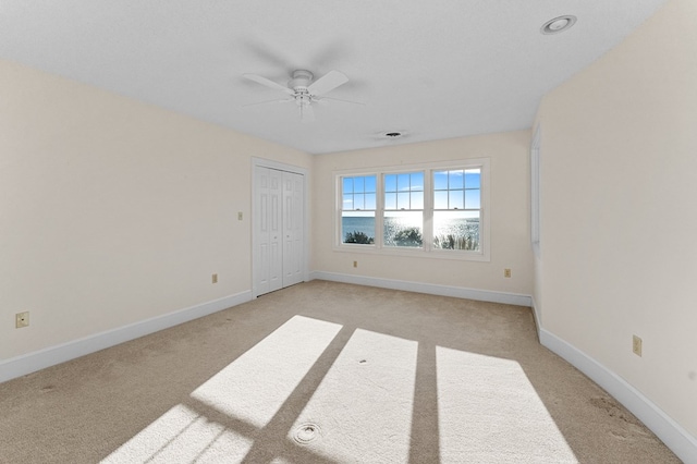 carpeted spare room with ceiling fan