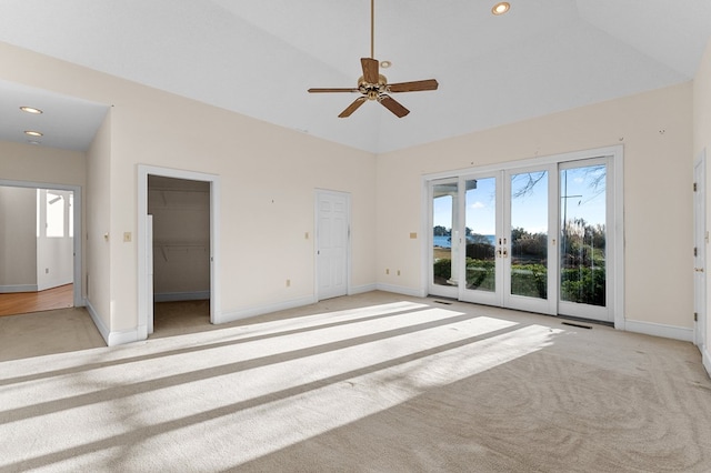 unfurnished bedroom featuring access to exterior, ceiling fan, french doors, a walk in closet, and a closet