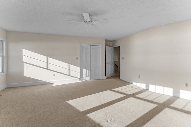 carpeted spare room featuring a textured ceiling and ceiling fan