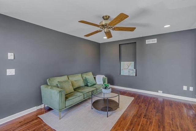 living room with ceiling fan and dark hardwood / wood-style flooring