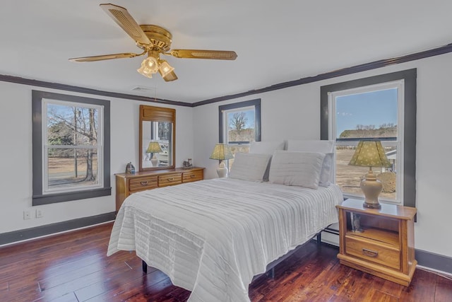 bedroom with ceiling fan, a baseboard heating unit, dark wood-type flooring, and crown molding