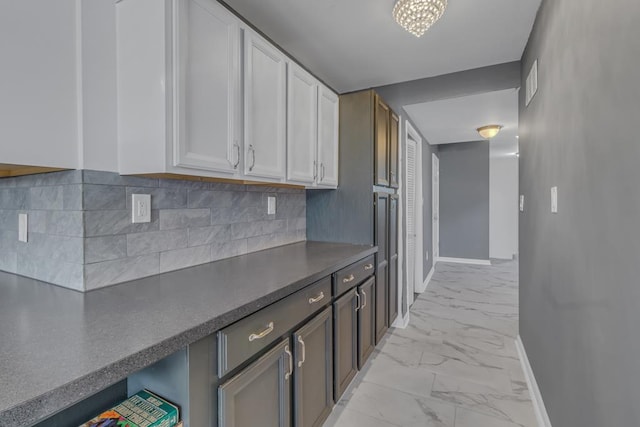 kitchen with dark brown cabinets, backsplash, and white cabinets