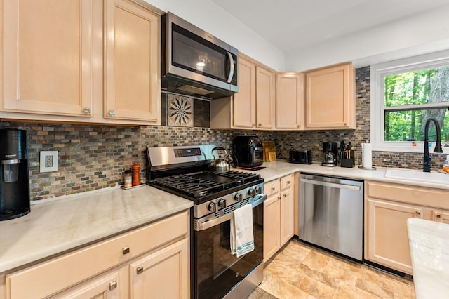 578 Canvasback Ln, Heathsville, VA 22473 - kitchen with stainless steel appliances, a sink, light brown cabinetry, and tasteful backsplash
