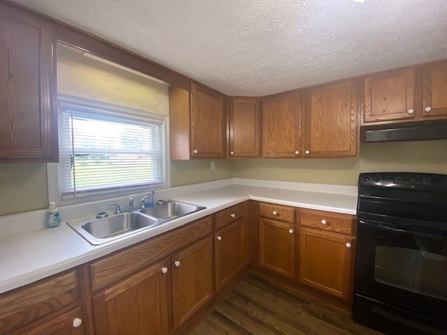 3097 Oakland Rd, Farnham, VA 22460 - kitchen featuring black / electric stove, under cabinet range hood, brown cabinets, dark wood-style floors, and light countertops