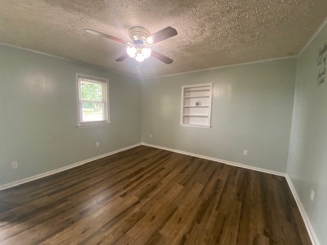 3097 Oakland Rd, Farnham, VA 22460 - spare room featuring a textured ceiling, built in shelves, ornamental molding, dark wood-style floors, and a ceiling fan