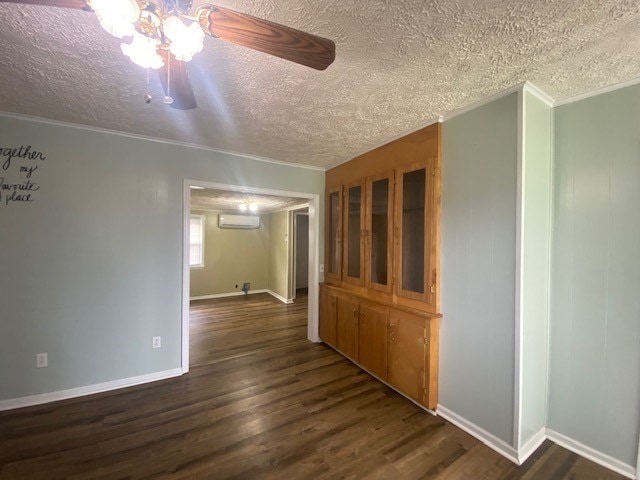 3097 Oakland Rd, Farnham, VA 22460 - spare room with a wall unit AC, a textured ceiling, crown molding, dark wood-style floors, and a ceiling fan