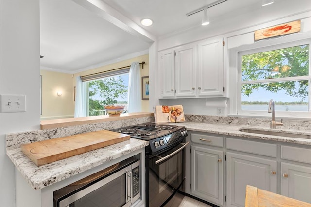 1743 Bushfield Rd, Montross, VA 22520 - kitchen featuring black range, stainless steel microwave, healthy amount of natural light, white cabinets, and crown molding