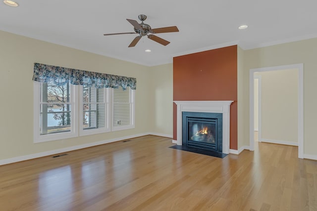 unfurnished living room featuring light hardwood / wood-style floors, ceiling fan, and crown molding