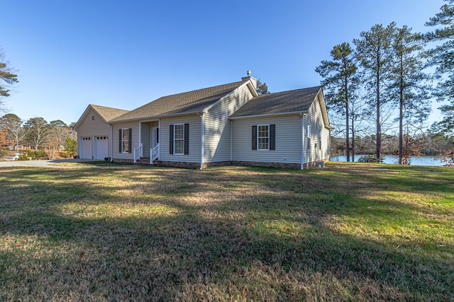 ranch-style house with a front yard, a water view, and a garage