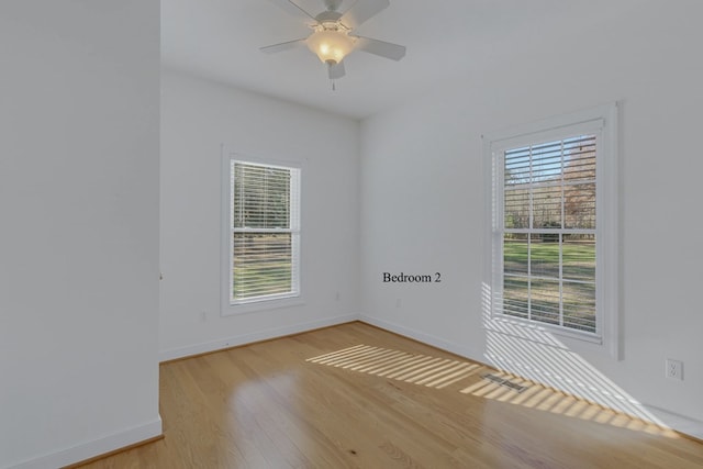 unfurnished room featuring plenty of natural light, ceiling fan, and light hardwood / wood-style flooring