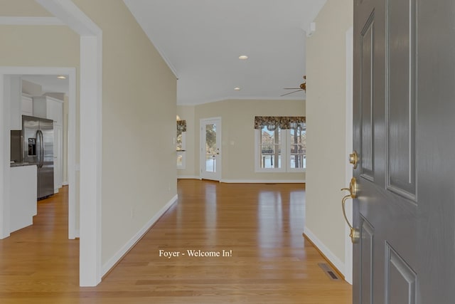 entrance foyer with crown molding, ceiling fan, and light wood-type flooring