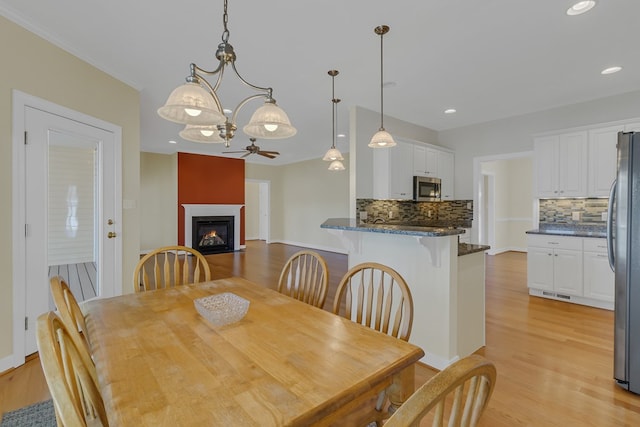 dining area featuring ceiling fan and light wood-type flooring