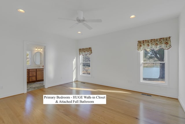 spare room with ceiling fan, plenty of natural light, and light wood-type flooring