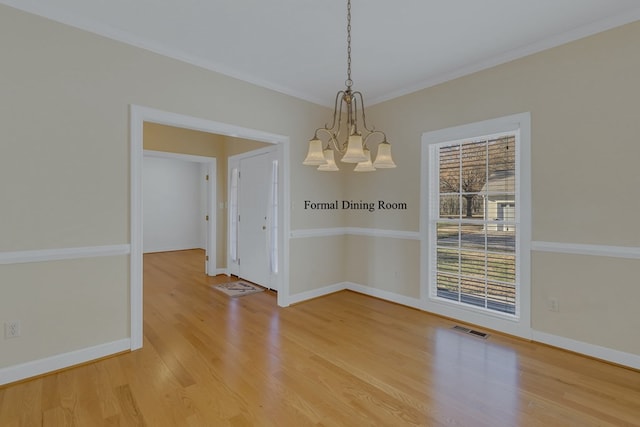 unfurnished dining area with hardwood / wood-style floors, a chandelier, and ornamental molding