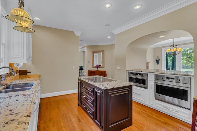 858 Harmony Hills Cir, Heathsville, VA 22473 - kitchen featuring black electric stovetop, oven, a chandelier, arched walkways, and light wood-style flooring