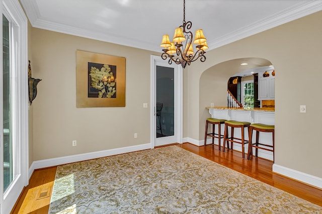 858 Harmony Hills Cir, Heathsville, VA 22473 - empty room featuring arched walkways, a chandelier, wood finished floors, and ornamental molding