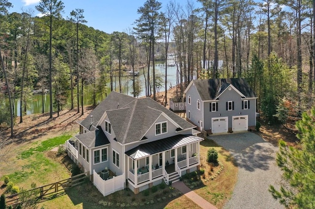 birds eye view of property with a water view and a wooded view