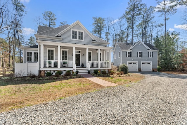 view of front of home featuring covered porch, a front lawn, gravel driveway, and a garage