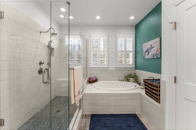 bathroom featuring a bath, recessed lighting, and a stall shower