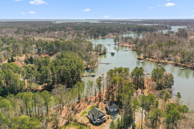 aerial view with a water view and a wooded view